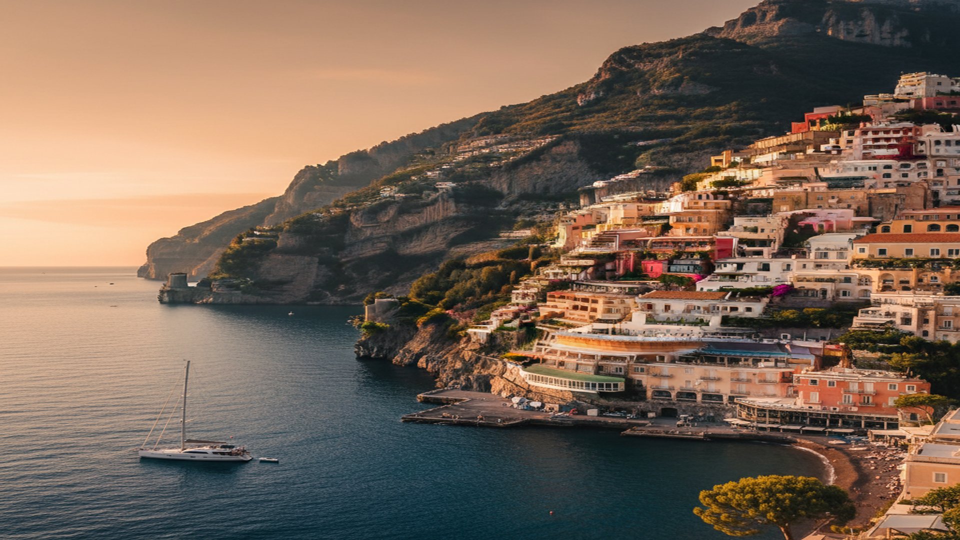 An iconic Mediterranean cliffside village at golden hour — pastel villas rising from a deep navy sea, a single yacht anchored offshore. A quiet emblem of premium investment migration.